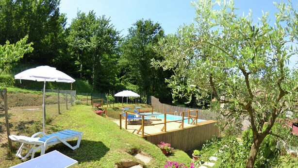 A backyard with a wooden deck, a swimming pool, lounge chairs, and potted plants. - Holiday Home in Lucca With Pool & Garden (Capannori)
