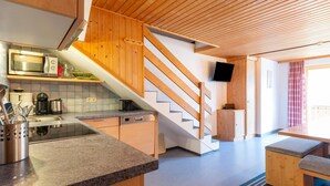 A modern kitchen with granite countertops, stainless steel appliances, and wooden cabinetry. - Spacious Apartment Near Centre and ski Area (Gaschurn)