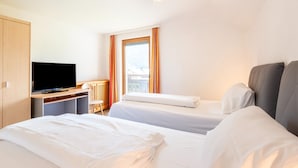 Une chambre d’hôtel avec deux lits, une télévision et un bureau.