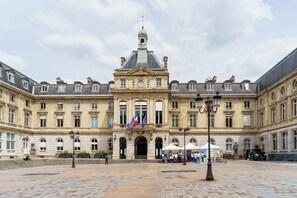 A historic building with a central entrance, multiple windows, and a clock tower. - PARI-PEC534 Summary: (Paris)