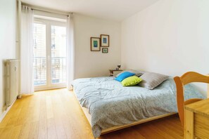 A bedroom with a bed, a nightstand, a lamp, and a view through a window. - PARI-PEC534 Summary: (Paris)