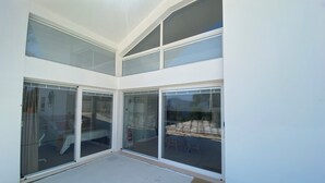A modern, multi-level interior with large glass doors leading to an outdoor area.
