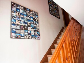 A staircase with wooden railings and a wall adorned with a collage of photographs. - Spacious House In Fugen With Terrace (Fuegen)