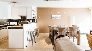 A modern kitchen with white cabinets, a central island with stools, and pendant lighting. - Amandari Igv01 Near the Center in Koksijde (Koksijde)