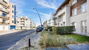 A residential street with modern apartment buildings, a cobblestone sidewalk, and parked cars. - Amandari Igv01 Near the Center in Koksijde (Koksijde)