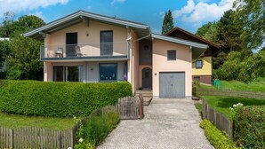 A two-story house with a balcony, a garage, and a well-maintained garden. - Holiday Home Attersee Near Hiking Trails (Attersee)