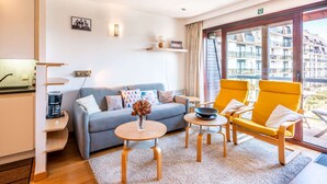 A modern living room with a grey sofa, yellow armchairs, a small round table, and a coffee machine. - Cosy Apartment in Koksijde Near the Beach (Koksijde)
