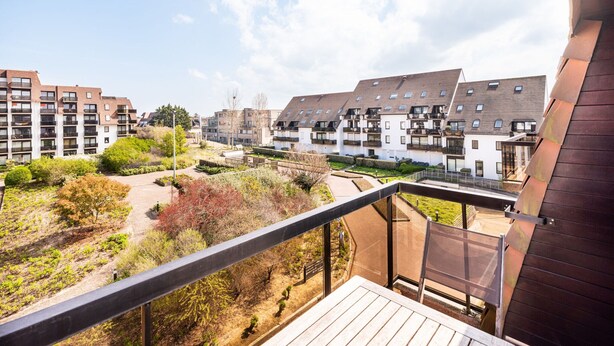 A residential building with multiple floors, balconies, and a garden area. - Cosy Apartment in Koksijde Near the Beach (Koksijde)