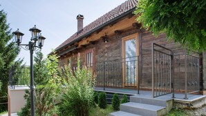A wooden cabin with a stone staircase leading to a wooden deck.