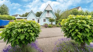 A row of light blue houses with white trim and a central house with a balcony. - Holiday Home by Zuidlaardermeer With Jetty (Kropswolde)