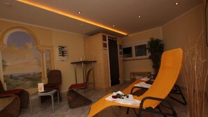 Ein Zimmer mit zwei gelben Lounge-Sesseln, einem kleinen Tisch, einem Bild an der Wand und einer Tür zu einem anderen Raum.