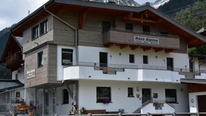 Ein zweistöckiges Gebäude mit einem Schild, auf dem "Haus Alpena" steht.
