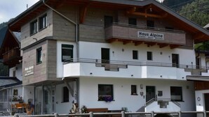 Un edificio de dos pisos con un cartel que dice 'Haus Alpena'.