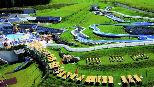 A resort with a swimming pool, sun loungers, and a water slide. - Dachgeschoss-atelier (Seefeld in Tirol)