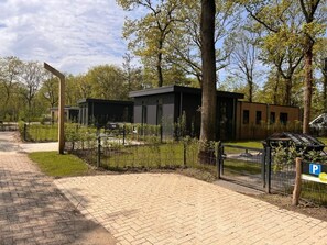 Experience a peaceful retreat amidst a serene garden setting, with a paved pathway leading to a comfortable accommodation.