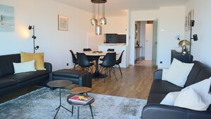 Una sala de estar moderna con sofá, mesa de centro y comedor.