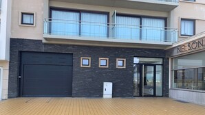 A modern building with a black garage door, a small window, and a glass entrance. - Apartment in Nieuwpoort Near Marina Views (Nieuwpoort)
