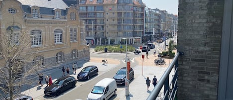 A street view with buildings, cars, and pedestrians.