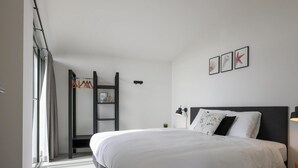 A modern bedroom with a large bed, a built-in wardrobe, and a small bedside table. - Inviting Holiday Home in the Nature (Wissenkerke)