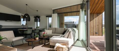 A modern living room with a sofa, coffee table, and dining area.