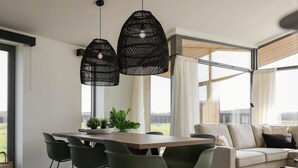 A modern dining area with a wooden table, green chairs, and black pendant lights. - Inviting Holiday Home in the Nature (Wissenkerke)