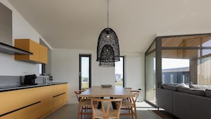 A modern kitchen with a dining area and a large window. - Holiday Home Wissenkerke Near Nature Reserve (Wissenkerke)