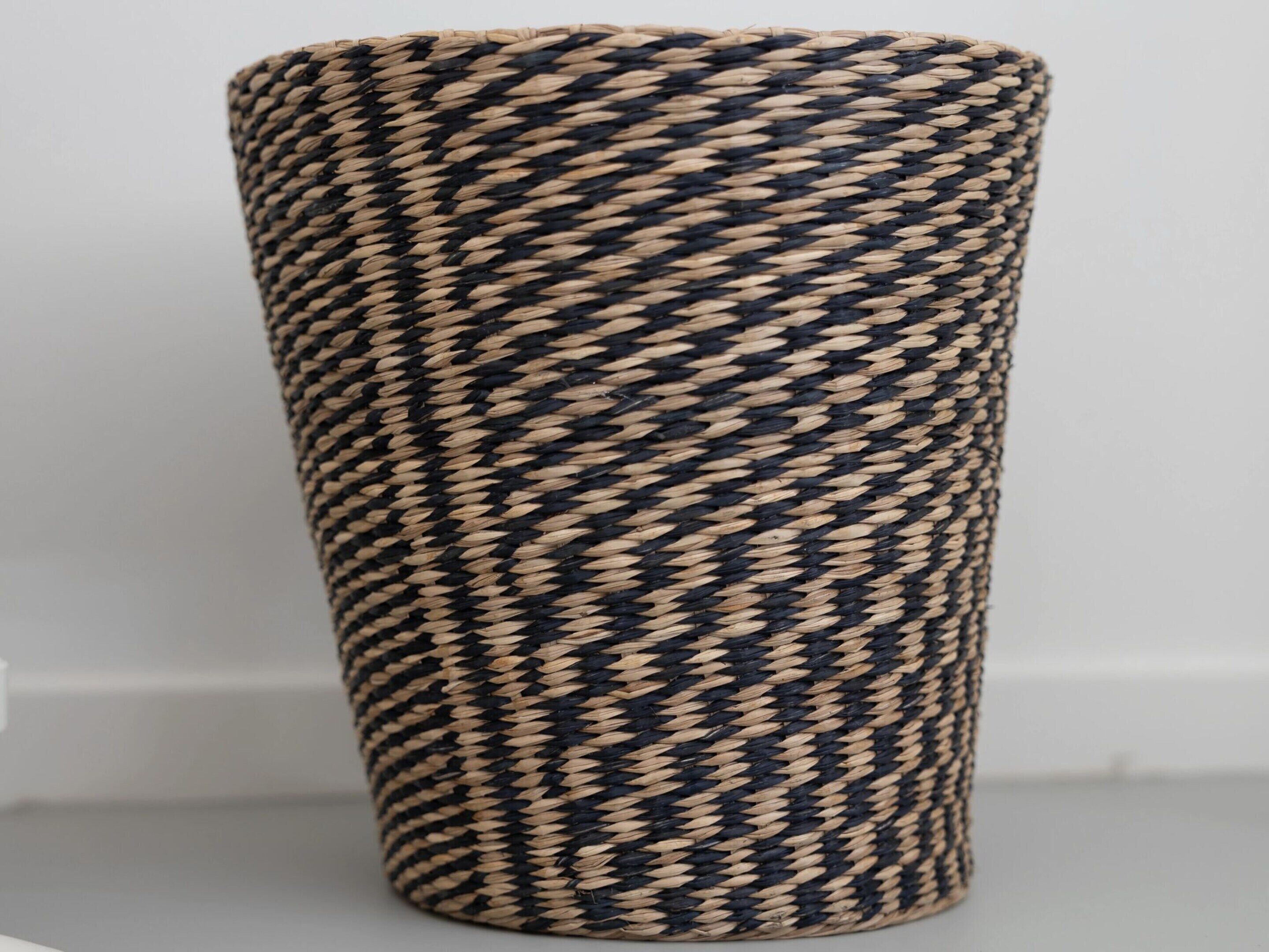 A cylindrical woven basket with a zigzag pattern.