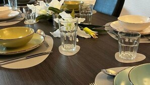 A dining table set with plates, bowls, glasses, and cutlery. - Lovely Apartment Near the Water (Weilburg)