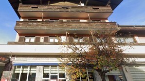 Um edifício de vários andares com telhado plano e amplas janelas no andar térreo.