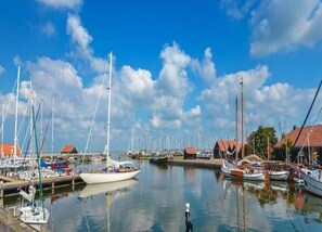 Un port de plaisance où sont amarrés de nombreux voiliers, entouré d’immeubles aux toits rouges.
