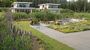 Ett modernt hus med en trädgård framför.