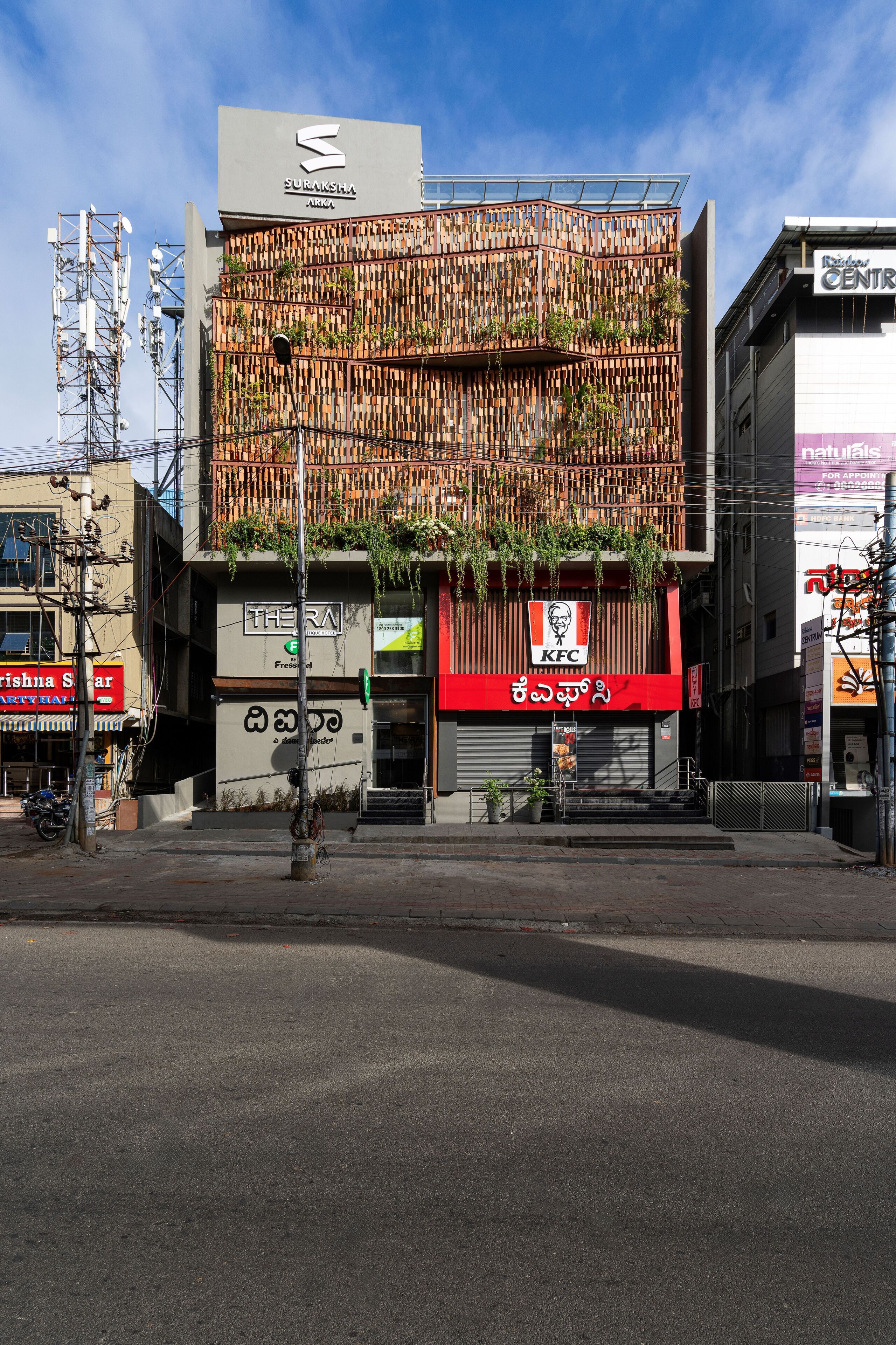 A building with a KFC sign, a sign for 'Sukisara Arka', and a 'Thera' sign.