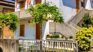 A two-story house with a balcony, a staircase, and a fence. - Cosy Apartment 200m From the sea (Ravenna)