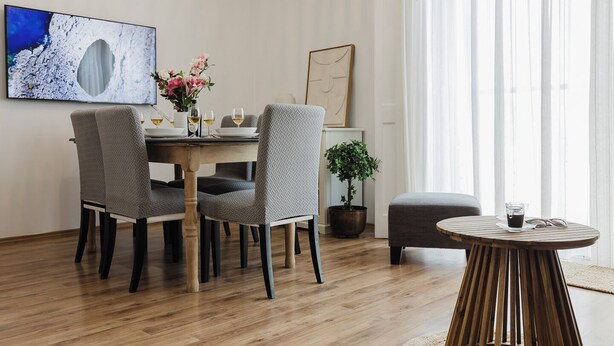 A dining area with a wooden table, two chairs, a potted plant, and a round wooden table with a glass. - Enjoy a stylish experience at this centrally-located place (San Pawl il-Baħar)