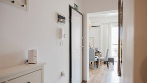 A hallway with a white door, a thermostat, and a phone on the wall. - Enjoy a stylish experience at this centrally-located place (San Pawl il-Baħar)