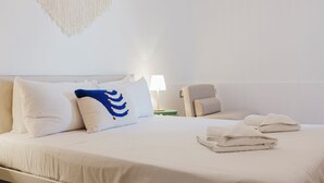 A neatly made bed with white linens, a blue and white pillow, and a folded towel on the side. - Enjoy a stylish experience at this centrally-located place (San Pawl il-Baħar)
