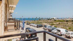 A parking area with several cars, a clear view of the beach, and a building with a sign reading "JASON'S CABS". - Enjoy a stylish experience at this centrally-located place (San Pawl il-Baħar)