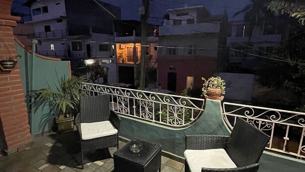 An outdoor patio area with wicker furniture and a tiled floor. - Centrally located apartment  (Puerto Vallarta)