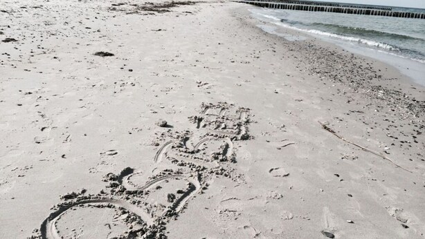 Una playa arenosa con huellas y un diseño circular.
