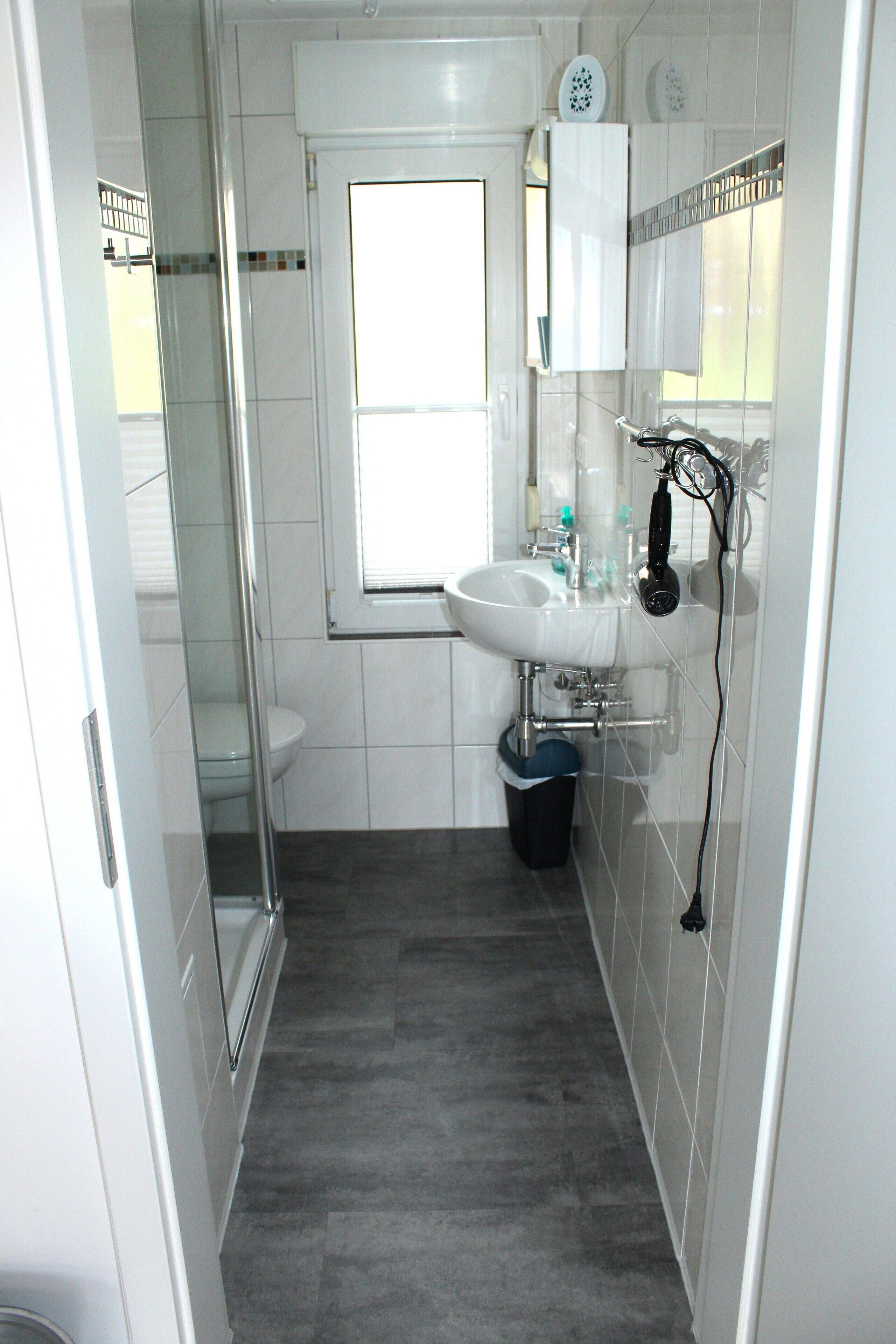 A bathroom with a white sink, a toilet, and a glass shower enclosure.