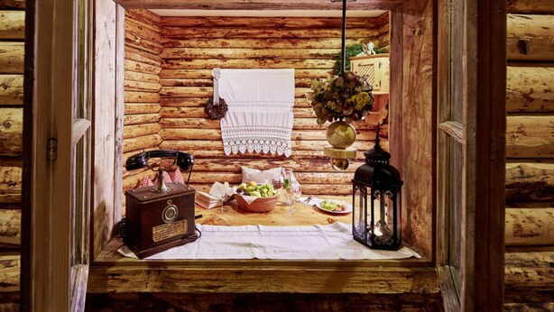 A rustic wooden cabin interior with a dining area, a vintage radio, and a hanging light fixture. - Maximilian 1-2 People (Neukirchen am Grossvenediger)