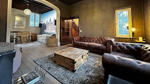 A spacious living area with a leather sofa, a wooden coffee table, and a rustic fireplace. - Luxurious Villa With Heated Pool (Gesves)