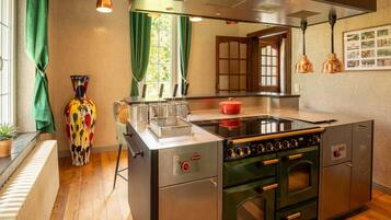 A modern kitchen with a central island, stainless steel appliances, and a view of the outdoors through a window.