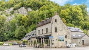 A stone building with a restaurant sign, located at a roadside with cars parked in front. - Luxurious Villa With Heated Pool (Gesves)
