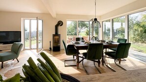 Un comedor moderno con una mesa grande, sillas y un televisor.