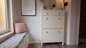 Une chambre à coucher comprenant un lit, une commode, un miroir et une œuvre d’art encadrée accrochée au mur.