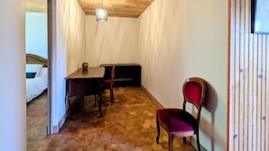 Ein Zimmer mit Holzboden, einem sechseckigen Fußbodenmuster, einem Bett, einem Tisch und einem Stuhl.