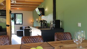 A dining area with a wooden table, leather chairs, a bowl of apples, and a wine glass. - Huis 3landenpunt AT-SLO-IT. Holiday in Austria, Slovenia and Italy at once. (Arnoldstein)