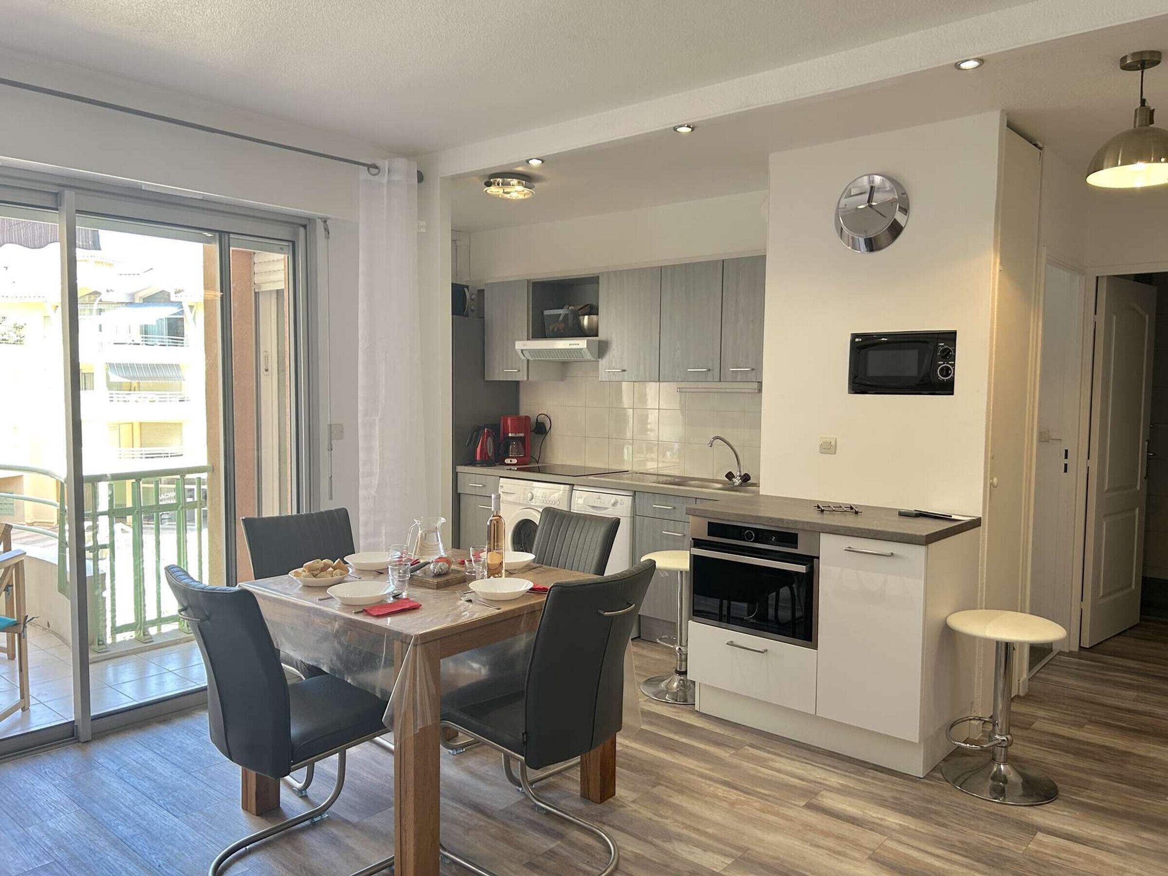 A modern kitchen with a dining area, a built-in oven, and a microwave.