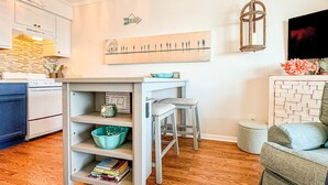 A kitchen with white cabinets, a wooden countertop, and a hanging light fixture. - Blue Pearl Oceanfront Modern at Sea Cabin w Pool (North Myrtle Beach)